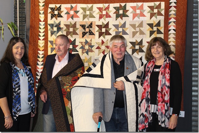 Vietnam veterans Russell McGregor (left) and Robert Renton (right) are presented with their Quilts of Valour by Helen Comport, founder of Quilts of Valour Australia.