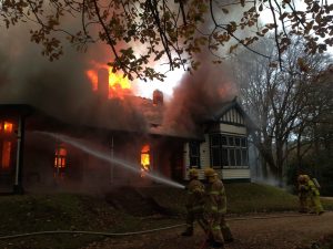 Firefighters work to save what they can as one of Mount Macedon's last hill station homes is engulfed by fire. Photo: Mike Dornau