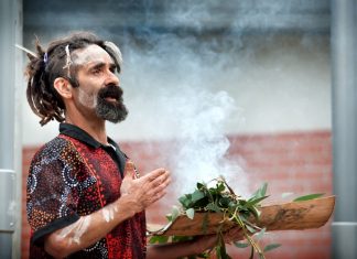 New beginning Proud Dja Dja Wurrung man Damien Saunders conducts a smoking ceremony at Trentham District Primary School last Friday morning to celebrate the installation of a new flag pole to fly the Aboriginal flag. "This ceremony today was the new beginning through the old for tomorrow's youth," he said. Photo: Sandy Scheltema