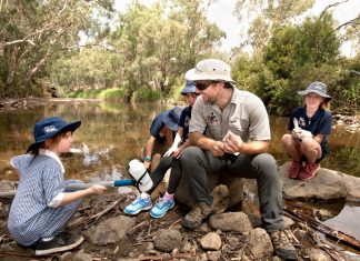 Platypus protectors Grade one student from Redesdale Mia Mia Primary School Lili Arnephy learns how to collect and filter water for DNA sampling from platypus ecologist Josh Griffith on the Campaspe River in Redesdale last Monday. Photo: Sandy Scheltema